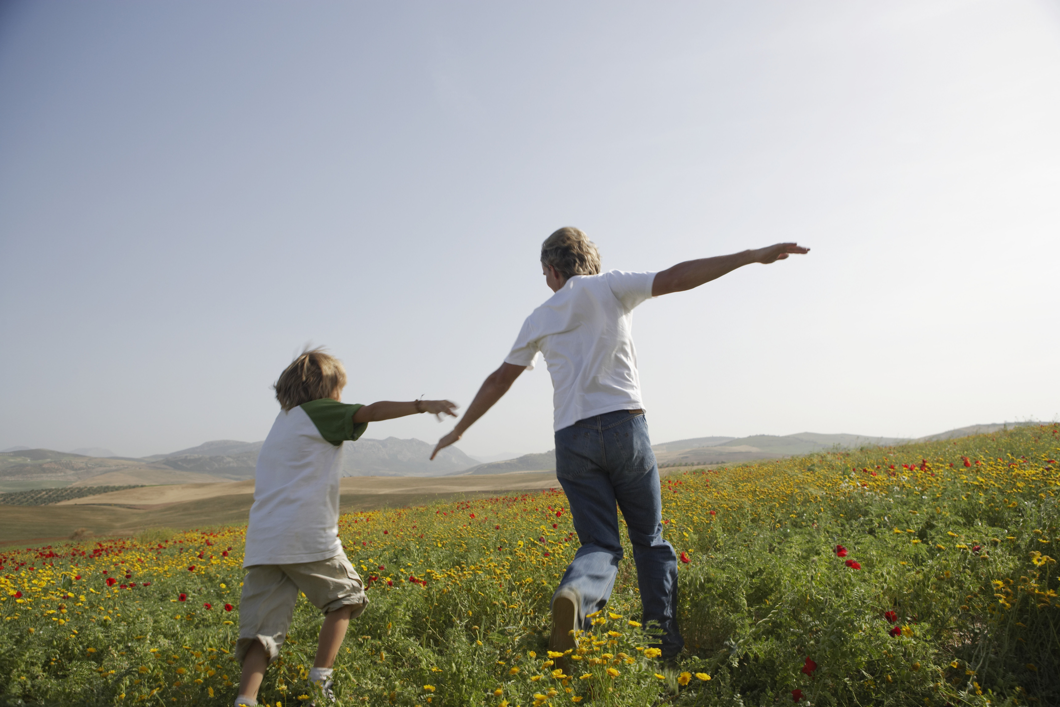 Father and son playing in a field on a sunny day