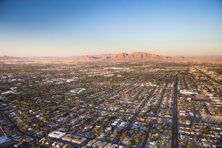 Aerial view across urban suburban communities seen from Las Vegas Nevada with streets, mountains, rooftops, and homes