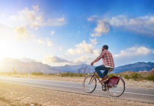 man riding bike into nevada sunset on empty highway by himself