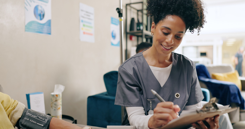 Medical assistant filling out a screening questionnaire for patient