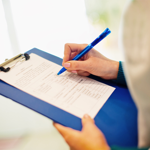 Medical professional filling out a form on a clipboard