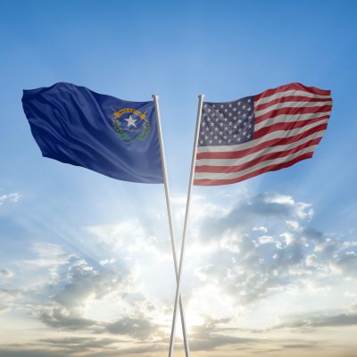 Flags of Nevada state and United states of America together waving in sky